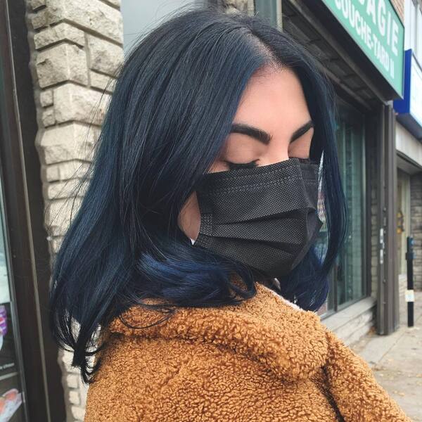 Black Hair with Blue Black Tips- a woman wearing a black face mask