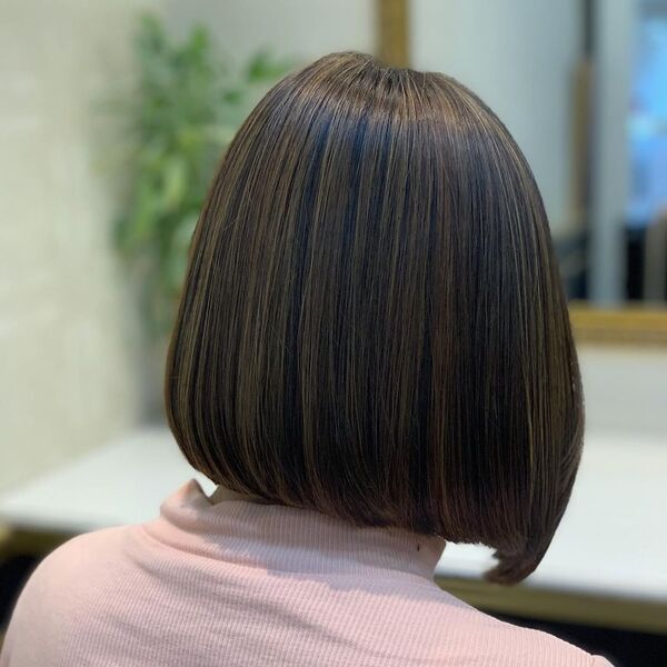 Blunt Bob with Brown Highlights - a woman wearing a light pink blouse