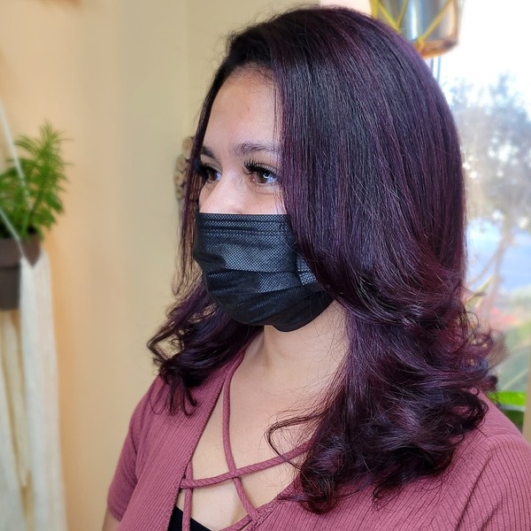 Brunette Hair with Purple Highlights- a woman wearing a black face mask