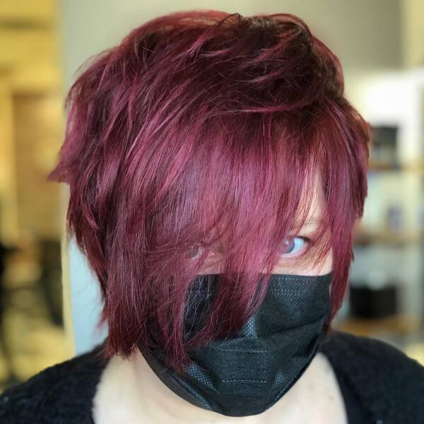 Burgundy Blush Hair Color Pixie Cut with Long Bangs- a woman wearing a black face mask