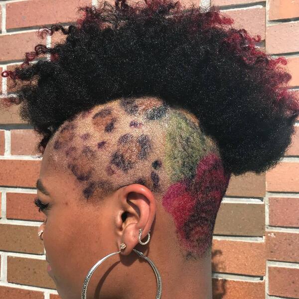 Curly Mohawk with Leopard Print Undercut- a woman wearing a big earring