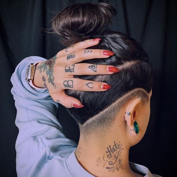 Faded Nape and Side Undercut Design with Messy Bun- a woman with a red nail polish