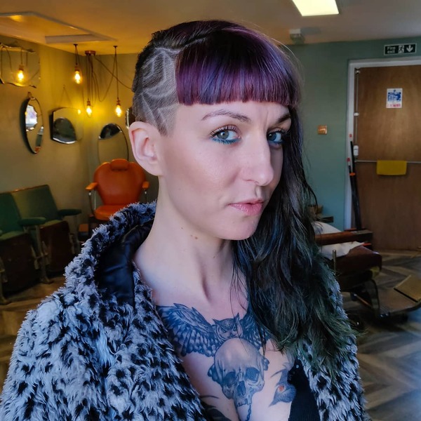 Intricate Side Undercut with Fringe and Messy Long Hair- a woman wearing a jacket