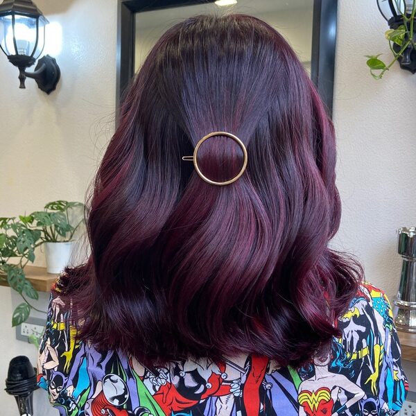 Medium-Length Brunette Hair with Plum Red Highlights- a woman wearing a blouse