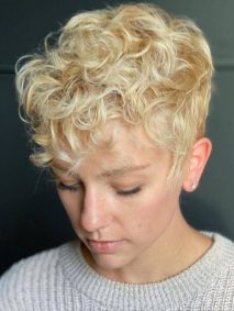 Messy Pixie Cut with Pure Blonde- a woman wearing a white sweater