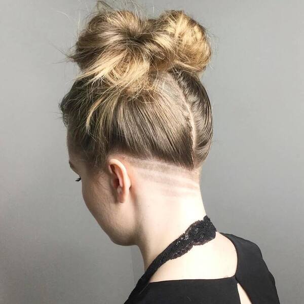 Nape Undercut Design with Middle-Part and Messy Bun- a woman wearing a black blouse