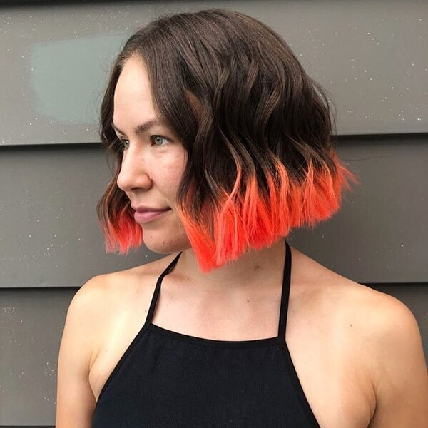 Orange Dip Dye Tips on Dark Hair- a woman wearing a black tank top