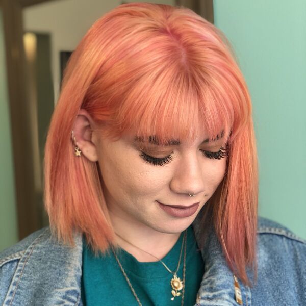 Peach Hair Color- a woman wearing a denim jacket