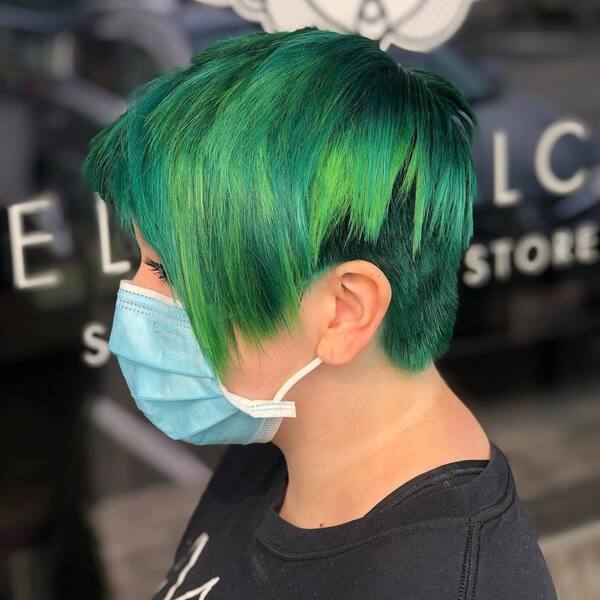 Pixie Cut with Emerald and Punk Green Hair Color- a woman wearing a face mask and a black t-shirt