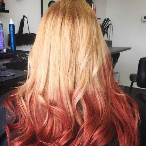 Reverse Blonde To Red Ombre Hairstyles- a woman wearing a black barber's cape