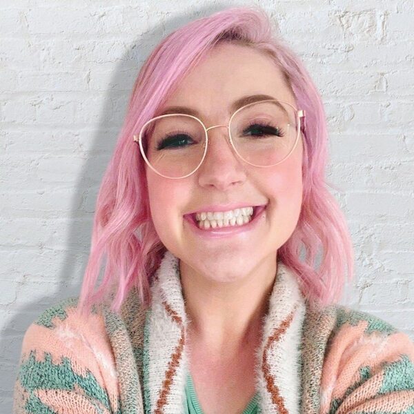 Short Wavy Hair with Bubblegum Pink Hair Color- a woman wearing an eyeglass