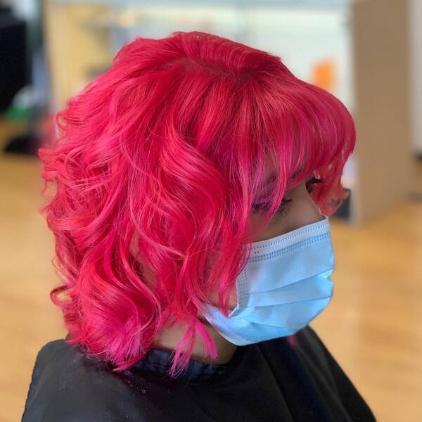 Short Wavy Hair with Lava Pink Hair Color- a woman wearing a face mask
