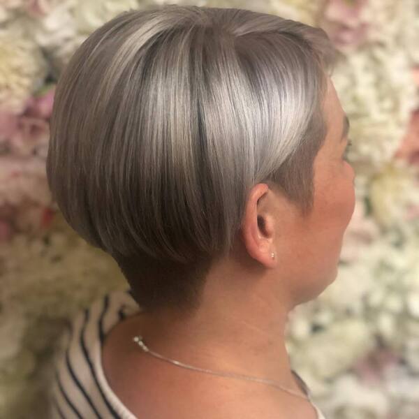 Side and Nape Undercut Design with Silver and Sleek Short Hair- a woman wearing a necklace