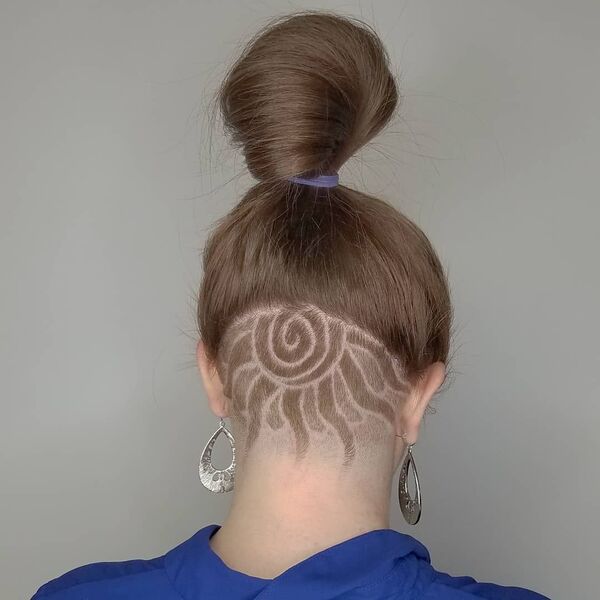 Spiral Nape and Side Undercut Design with Ponytail- a woman wearing a big pair of earrings
