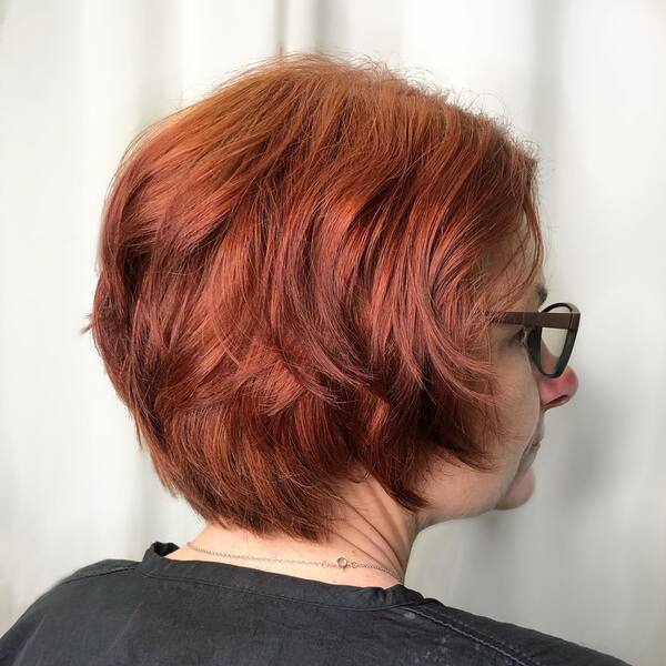 Textured Bob with Vivacious Red Hair Color- a woman wearing a black t-shirt