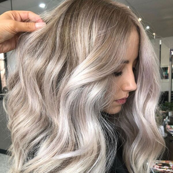 The Silver Blond Ombre- a woman wearing a black barber's cape