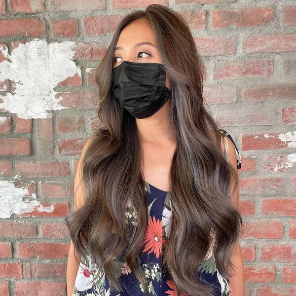 Ash Brown Long Wavy Hair- a woman wearing a black face mask