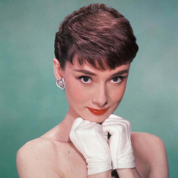 Audrey Hepburn's Pixie Cut- Audrey Hepburn wearing a white fashion gloves
