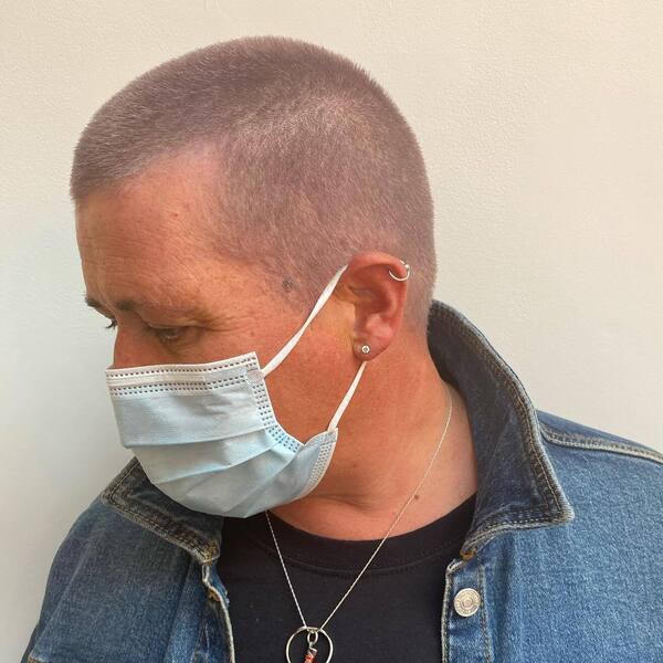 Buzz Haircuts for Women- a woman wearing a face mask and a denim jacket
