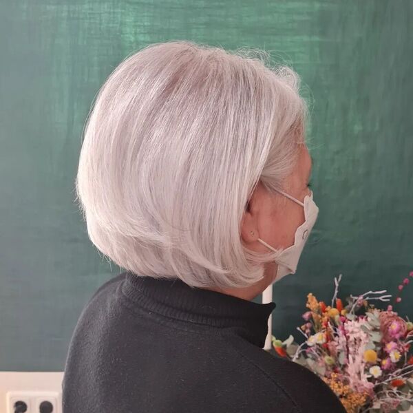 Classic Bob with a Twist- a woman wearing a white face mask