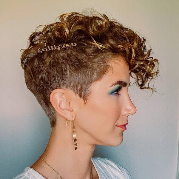Classy Pixie Cut- a woman wearing a white shirt and a pair of earrings