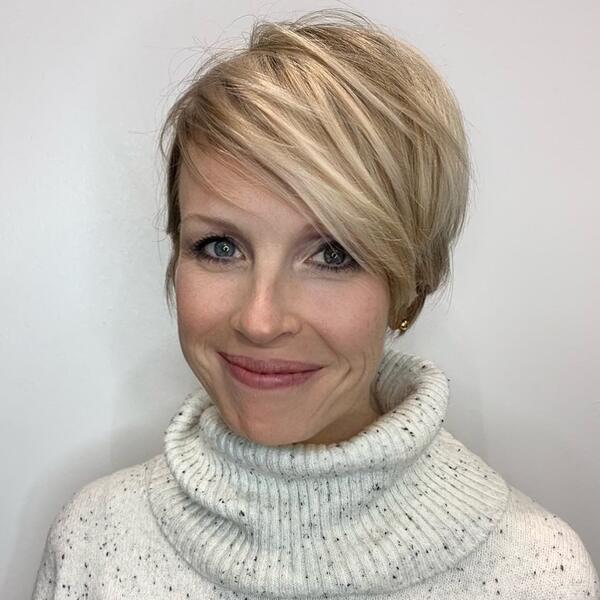 Creamy Blonde Pixie Haircut- a woman wearing a white turtle neck sweater