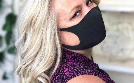 Creamy Blonde Wavy Hair- a woman over 60 wearing a black face mask