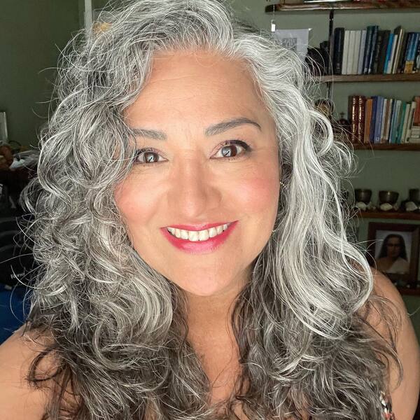 Curls for Gray Hair- a woman with gray hair wearing a black camisole