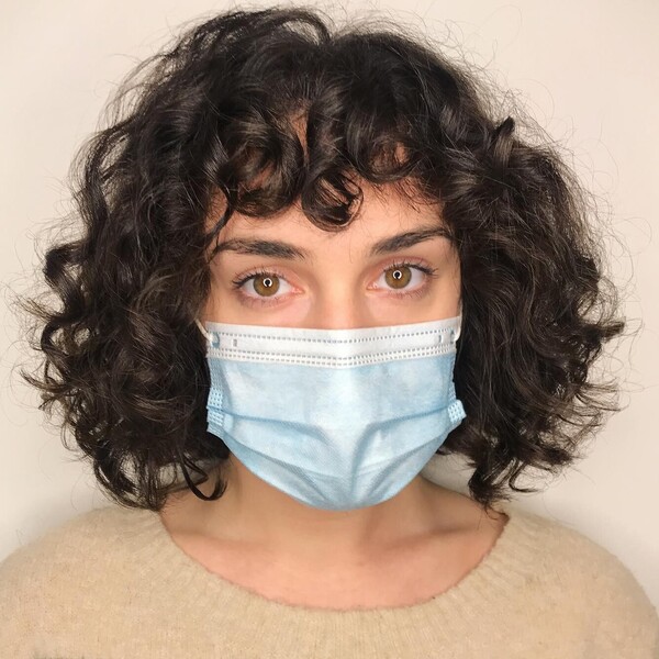 Curly Bob Cut- a woman wearing a face mask