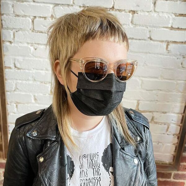 Edgy Mullet with Short Bangs- a woman wearing a black face mask and a black leather jacket