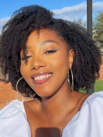 Frizzy Curls for Black Women- a black woman wearing a white dress