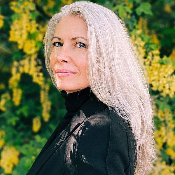 Fully Grown Gray Hair- a woman with gray hair wearing a black suit