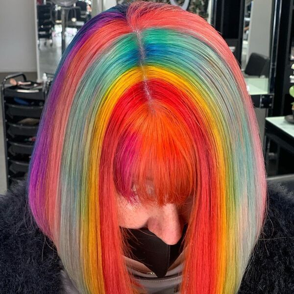 Fun Bright Rainbow Colored Hair- a woman wearing a black face mask