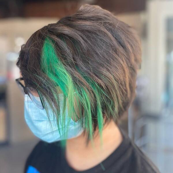 Green Streak Pixie Cut- a woman wearing a face mask and a black t-shirt