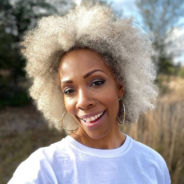 Growing Out Afro Gray Hair- a woman with gray hair wearing a white t-shirt