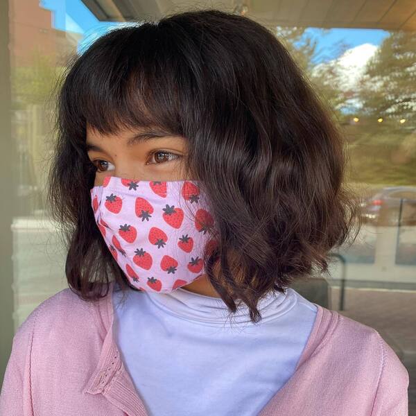 Happy Fluffy Hair- a woman wearing a pink face mask with pink sweater