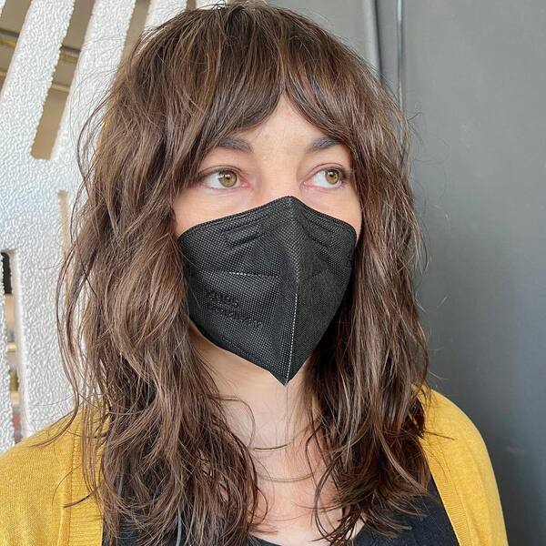 Heavy Shag Haircut- a woman wearing a black face mask