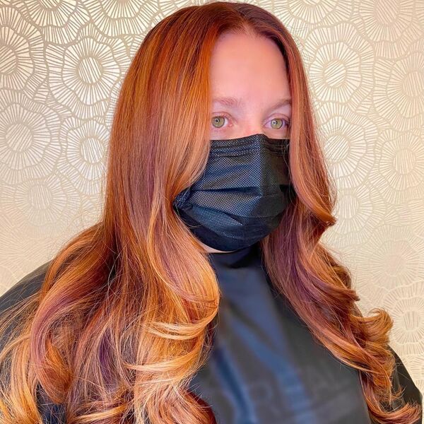Highlighted Fall Hair Color- a woman wearing a black face mask and a black barber's cape