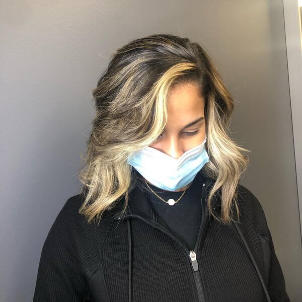 Highlighted Hairstyles for Thin Hair- a woman wearing a face mask and a black jacket