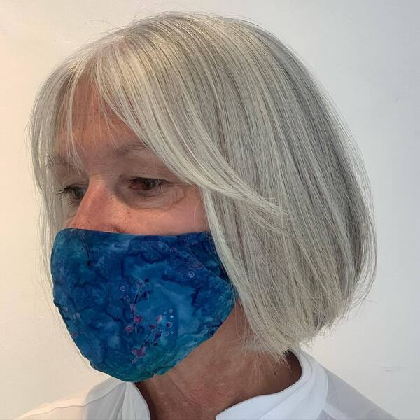 Layered Bob Hairstyles for Women Over 60- a woman over 60 wearing a blue face mask