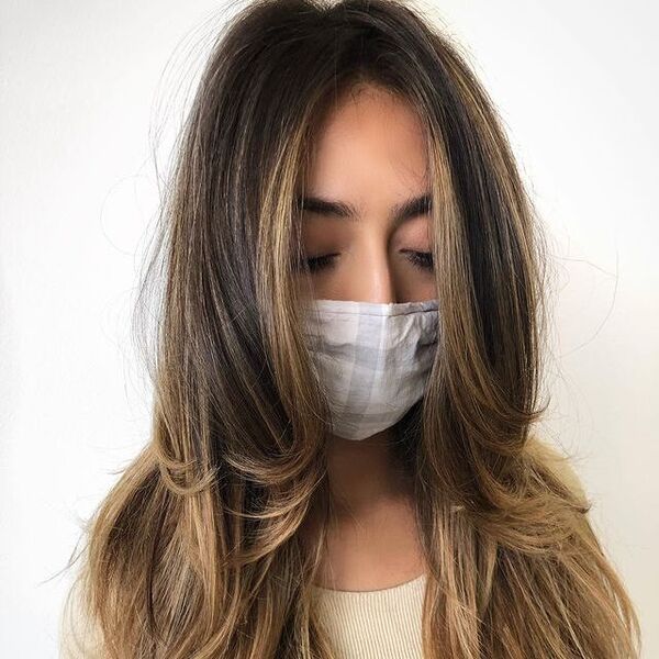 Layered Hairstyles for Thin Hair- a woman wearing a white face mask