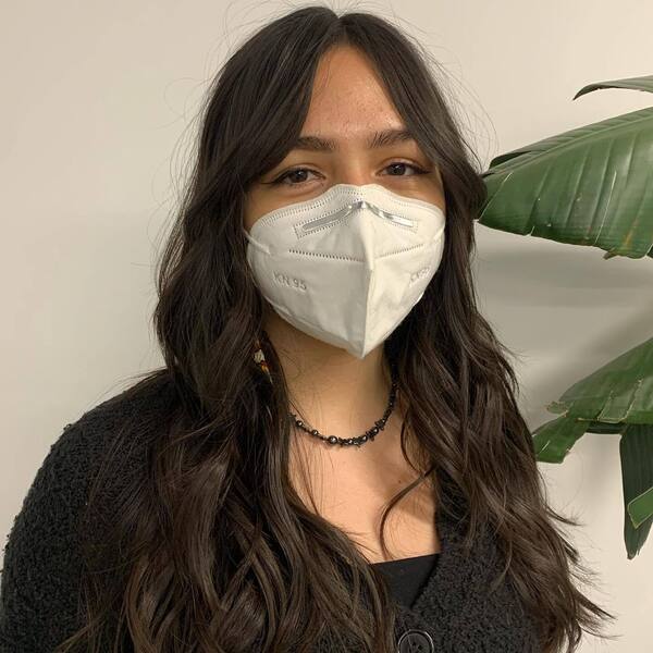 Long Brown Hair with Face Framing Curtain Bangs- a woman wearing a white face mask