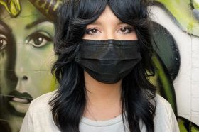 Long Layered Shag- a woman wearing a black face mask