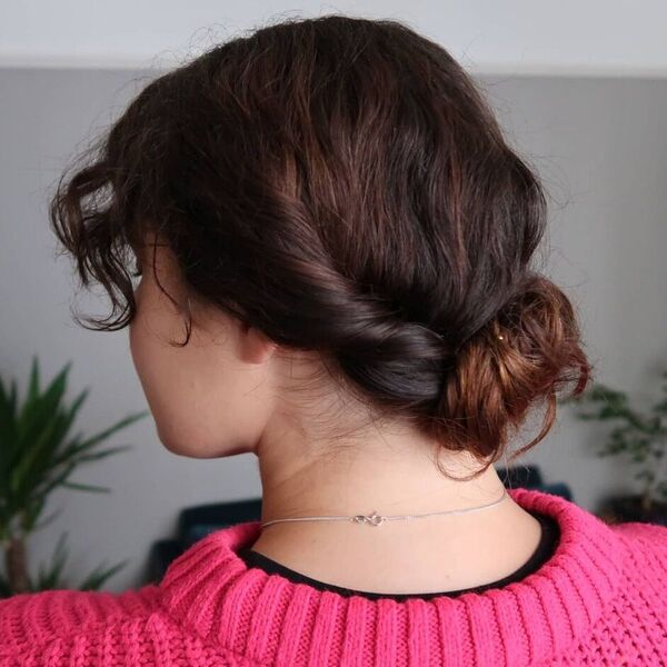 Low Knot Updo- a woman wearing a pink sweater