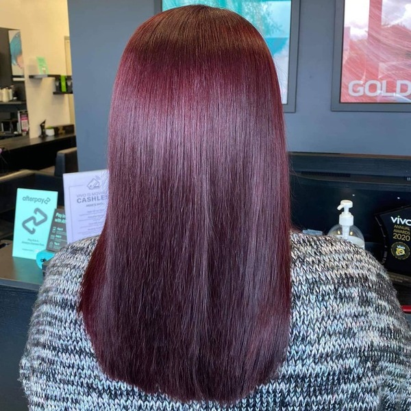 Mahogany Hair Color with Red and Violet Undertones- a woman wearing a gray sweater