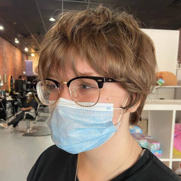 Messy Choppy Pixie Cut for Brown Hair- a woman wearing a face mask and a black t-shirt