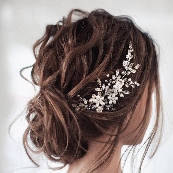 Messy Curly Bridal Updo Hairstyle- a woman wearing a wedding dress