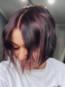 Mid Split Bob Cut with Violet Highlights- a woman wearing a white sweater