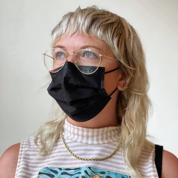 Mullet Shag Haircut- a woman wearing a black face mask