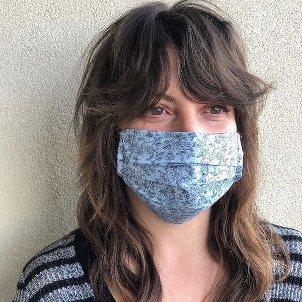 Natural Waves Shaggy Hairstyle- a woman wearing a face mask